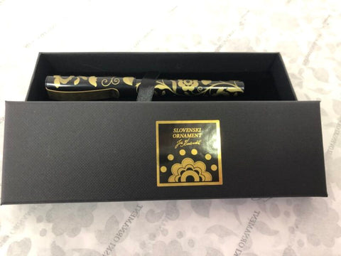 Elegant black fountain pen with a gold ornament and gold clasp in a box